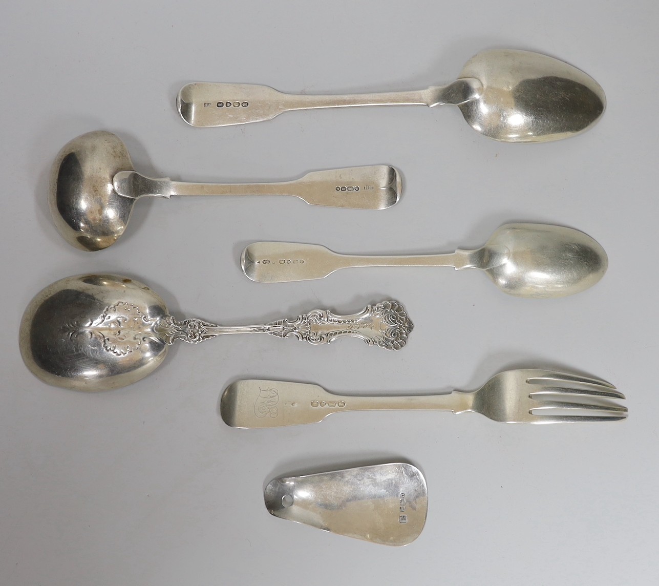 Four assorted items of silver flatware, a sterling serving spoon and a George V silver shoe horn (lacking ring), 10.6oz.